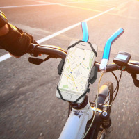 Czarny uchwyt rowerowy Spigen A251 zamontowany na kierownicy roweru, stabilnie podtrzymujący iPhone z włączoną nawigacją mapową podczas jazdy w świetle dnia.