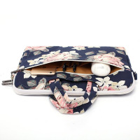 Etui Canvaslife do MacBook Pro 15 w kwiatowy wzór z otwartą kieszenią zewnętrzną, w której umieszczono smartfon, dwa długopisy oraz białą myszkę komputerową.