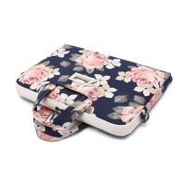 Etui Canvaslife do MacBook Pro 15 z kwiatowym wzorem na granatowym tle, posiada jasne uchwyty, zamek błyskawiczny oraz naszywkę z logo marki na froncie.