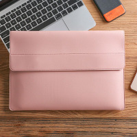 Różowe etui Tech-Protect Chloi do MacBook Air i Pro 13 leży na drewnianym blacie obok otwartego laptopa Apple z widoczną klawiaturą i powerbankiem Stryfer.