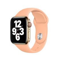 Złoty Apple Watch z tarczą wskazującą godzinę 9:03 oraz silikonowy pasek Apple w kolorze Cantaloupe, widok z profilu na kopertę z cyfrową koronką.