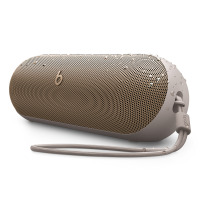Bezprzewodowy głośnik Beats Pill w kolorze szampańskiego złota z widocznymi kroplami wody na obudowie, wyposażony w praktyczną smycz z logo Beats.