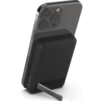 Czarny powerbank Belkin z podstawką przyczepiony magnetycznie do iPhone'a, widoczna wyspa aparatów smartfona oraz rozłożona nóżka z logo marki Belkin.