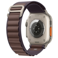 Widok od spodu na Apple Watch Ultra z tytanową kopertą 49 mm oraz granatowy pasek Alpine Loop z metalowym zapięciem, widoczne sensory tętna i napisy.