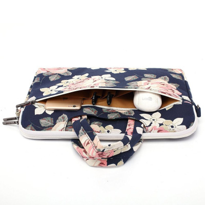 Etui Canvaslife do MacBook Pro 15 w kwiatowy wzór z otwartą kieszenią zewnętrzną, w której umieszczono smartfon, dwa długopisy oraz białą myszkę komputerową.