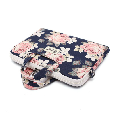 Etui Canvaslife do MacBook Pro 15 z kwiatowym wzorem na granatowym tle, posiada jasne uchwyty, zamek błyskawiczny oraz naszywkę z logo marki na froncie.