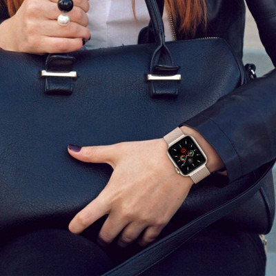 Różowa bransoleta mediolańska Tech-Protect na nadgarstku kobiety z czarną torebką, prezentująca elegancki Apple Watch z tarczą w kolorze różowego złota.