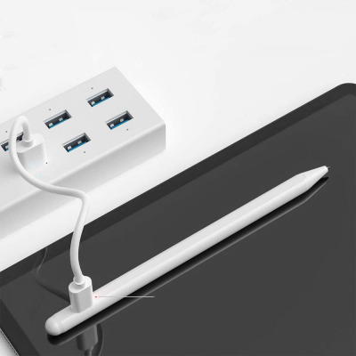 Biały rysik TECH-PROTECT Digital Stylus Pen do tabletu iPad leży na ekranie urządzenia, będąc podłączonym przewodem do białego koncentratora USB.