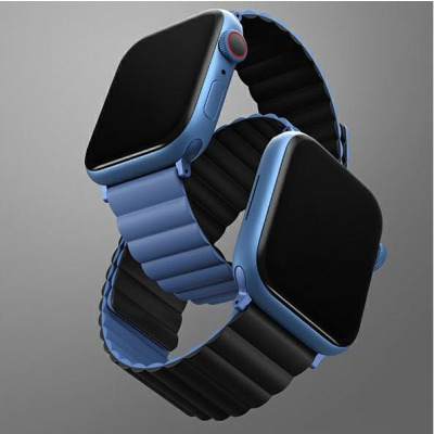 Dwukolorowy pasek Uniq Revix w kolorze czarno-niebieskim zamontowany do dwóch zegarków Apple Watch, prezentujący magnetyczne zapięcie i profil akcesorium.