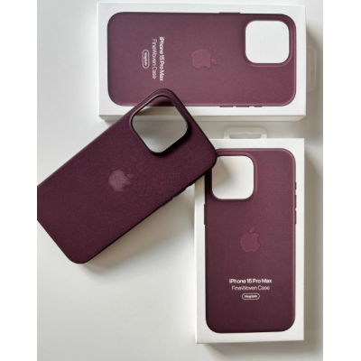 Rubinowe etui Apple FineWoven z MagSafe do iPhone 15 Pro Max leży obok dwóch białych opakowań z nadrukiem nazwy produktu i logo Apple na jasnym tle.