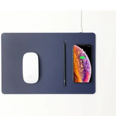Niebieska podkładka pod mysz Pout Wireless Charging Mouse Pad z białą myszką Apple Magic Mouse, czarnym rysikiem oraz ładującym się smartfonem iPhone.