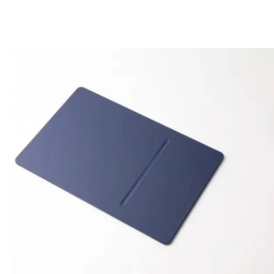 Niebieska podkładka pod mysz Pout Wireless Charging Mouse Pad z białą myszką Apple Magic Mouse, czarnym rysikiem oraz ładującym się smartfonem iPhone.