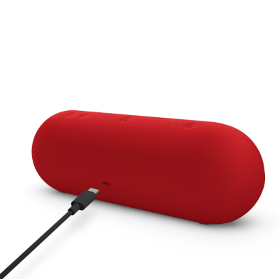 Czerwony głośnik Beats Pill w matowym wykończeniu, widok z tyłu na przyciski sterujące, diody oraz port ładowania USB-C z podłączonym kablem zasilającym.