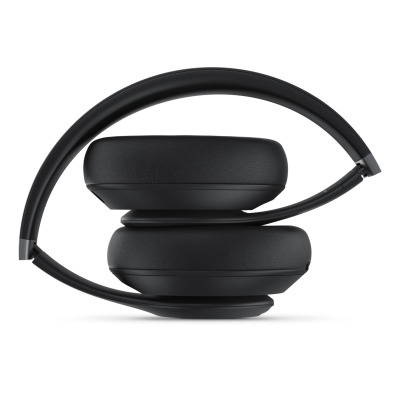 Czarne słuchawki Beats Studio Pro Wireless złożone w kompaktową formę, ukazujące profil konstrukcji z miękkimi nausznikami oraz wygiętym pałąkiem.