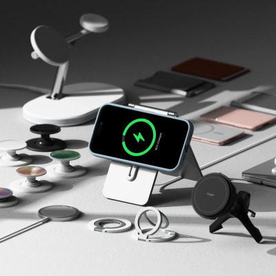 Niebieskie etui Ringke Silicone MagSafe na iPhone 16 umieszczone na podstawce ładującej, otoczone akcesoriami magnetycznymi na szarym tle, ekran 92%