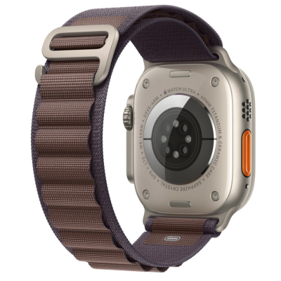 Pasek Apple Alpine Loop w kolorze indygo do Apple Watch 49mm, z widocznym tytanowym zapięciem typu G-hook oraz charakterystyczną teksturowaną strukturą splotu.